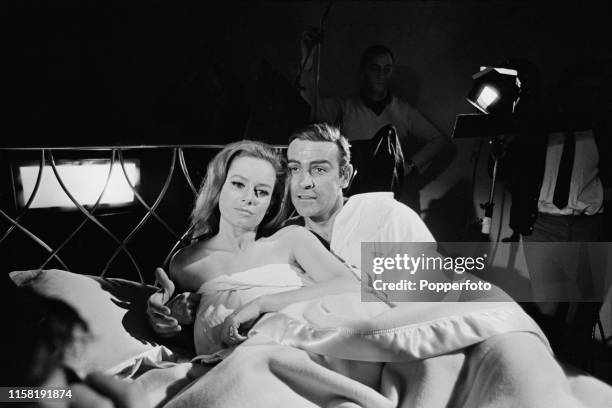 Scottish actor Sean Connery pictured in character as James Bond with Italian actress Luciana Paluzzi during the shooting of a bedroom scene from the...