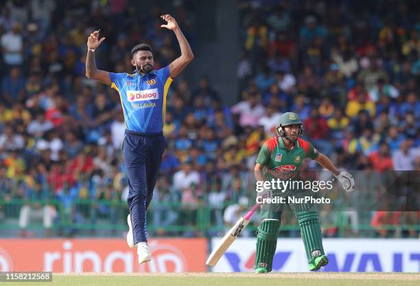 Sri Lankan cricketer Isuru Udana reacts watched by Bangladesh cricketer Mehidy Hasan during the 2nd One Day International cricket match between Sri...