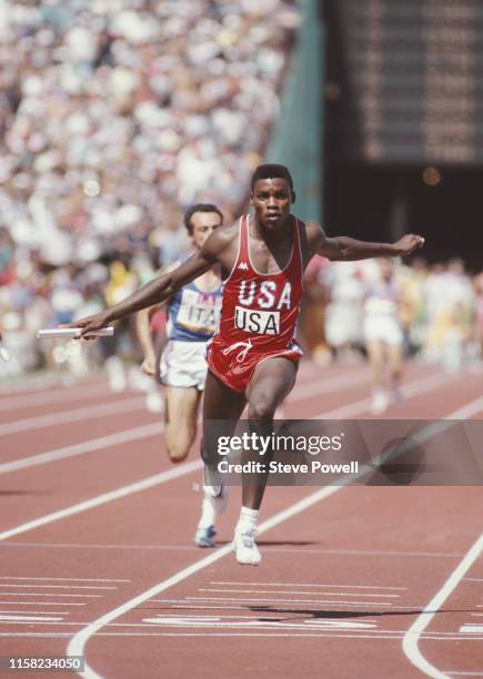 Carl Lewis of the United States carries the baton across the line to win the anchor leg of the Men's 4 x 100 Metres Relay at the XXIII Olympic Summer...