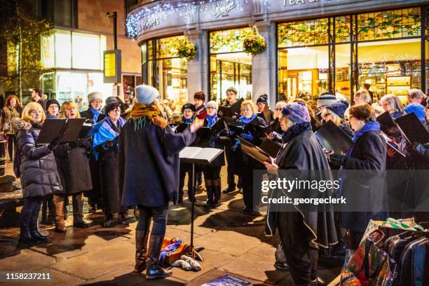 weihnachtschor singt nachts - christmas carols stock-fotos und bilder