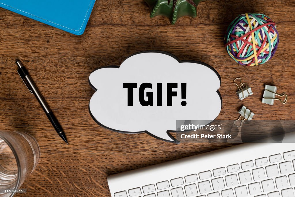 View from above paper TGIF speech bubble on wooden desk