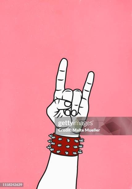 hand with studded cuff gesturing horn sign - horn sign stock illustrations