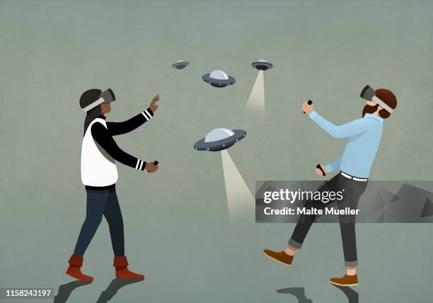 couple playing ufo video game with virtual reality simulator glasses - eskapismus stock-grafiken, -clipart, -cartoons und -symbole