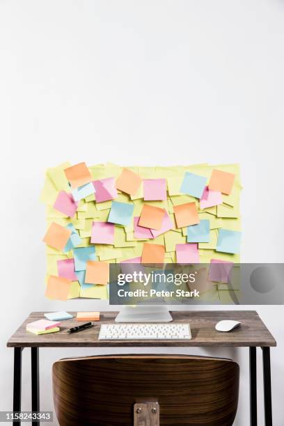 adhesive notes covering computer in office - sticky notes covering computer monitor stock-fotos und bilder
