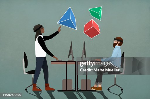 Computer programmers with virtual reality simulator glasses looking up at 3D geometric shapes Computer programmers with virtual reality simulator glasses looking up at 3D geometric shapes