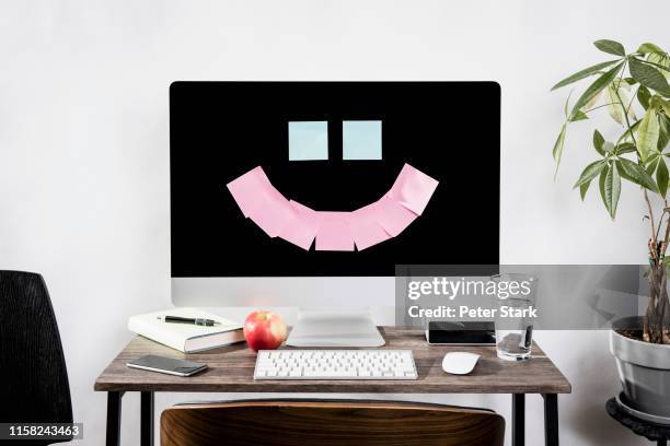 adhesive notes forming smiley face on computer - anthropomorphic smiley face - fotografias e filmes do acervo