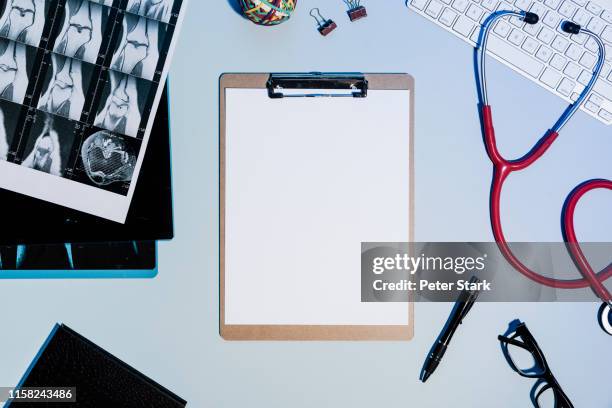 view from above blank paper on clipboard next to x-rays and stethoscope - clipboard stock pictures, royalty-free photos & images
