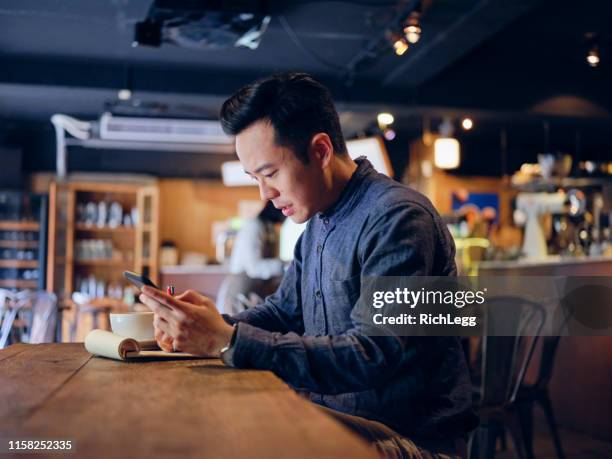 junger professioneller mann arbeitet in einem kleinen coffee shop - asian restaurant stock-fotos und bilder