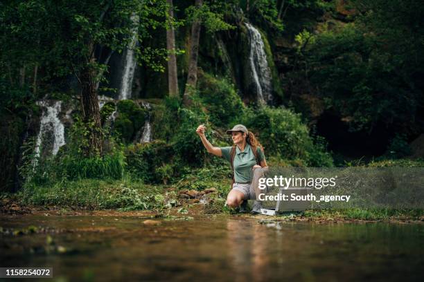 mujer tomando una muestra de agua - water conservation fotografías e imágenes de stock