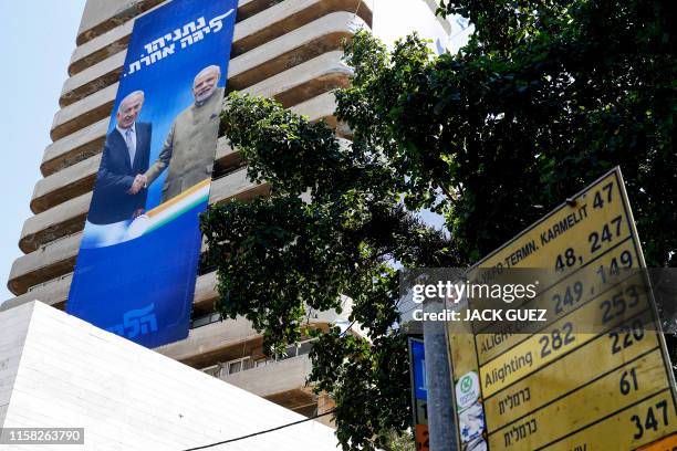 This picture taken on July 28, 2019 shows two giant Israeli Likud Party election banners hanging from a building showing Israeli Prime Minister...