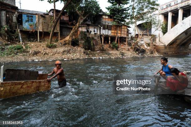 Mother bathes her daughter in the river at a slum area in Jakarta, Indonesia, July 28, 2019.