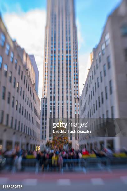 big christmas tree stands among midtown manhattan skyscraper between high-rise rockefeller center buildings at new york ny usa on dec. 25 2018. - rockefeller centre christmas stock pictures, royalty-free photos & images