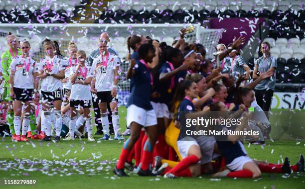 The Germany Women's U19 squad and coaches look on as the France Women's U19 team lift the European Championship trophy during the UEFA Women's...