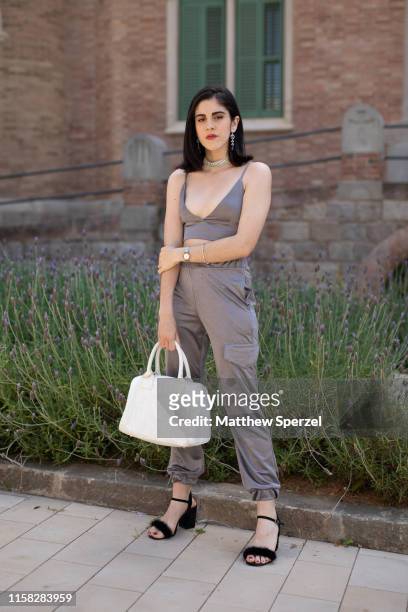 Guest is seen on the street attending 080 Barcelona Fashion week wearing grey crop top and cargo pants, white bag and black heels on June 25, 2019 in...