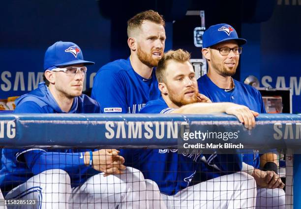 Eric Sogard of the Toronto Blue Jays stands behind teammates Danny Jansen, Billy McKinney, and Brandon Drury during play against the Tampa Bay Rays...