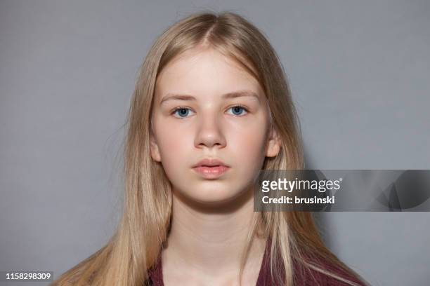 studio portrait of blonde teen girl on gray background - blonde hair girl stock pictures, royalty-free photos & images
