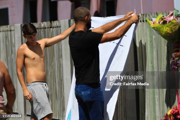 Jack Bethell and Jack Cooper hang a tribute banner for Mi Ayliffe-Chung at the Home Hill Backpackers, south of Townsville, where Smail Ayad allegedly...