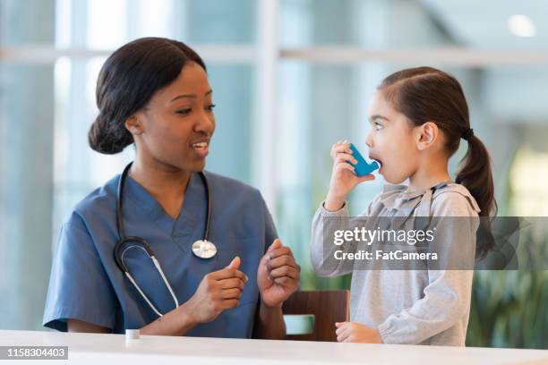 female doctor assists young asthmatic patient - respiratory system stock pictures, royalty-free photos & images