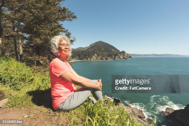 senior woman hiking on the oregon coast - senior women hiking stock pictures, royalty-free photos & images