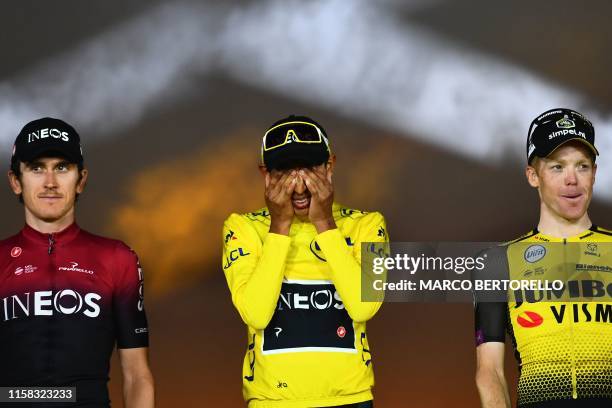 Colombia's Egan Bernal celebrates his overall leader's yellow jersey reacts as he poses with second-placed Great Britain's Geraint Thomas and...