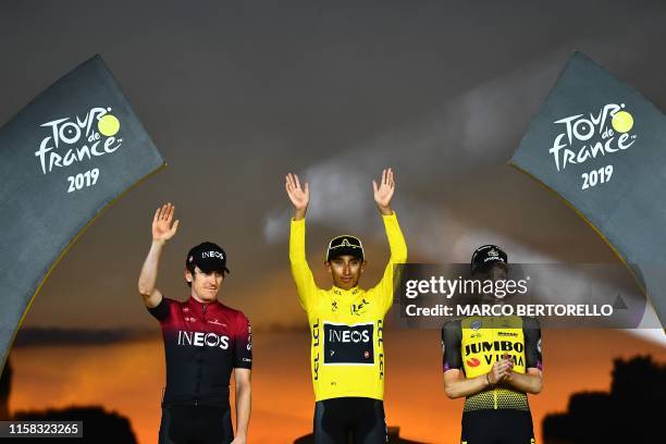 Colombia's Egan Bernal celebrates his overall leader's yellow jersey waves as he poses with second-placed Great Britain's Geraint Thomas and...