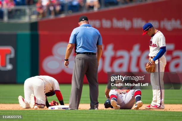 Umpire Mark Carlson and Cesar Hernandez of the Philadelphia Phillies look on after Jean Segura of the Philadelphia Phillies and Ronald Acuna Jr. #13...