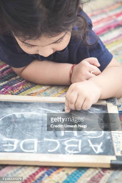 portrait of girl writing on slate - slate rock stock pictures, royalty-free photos & images