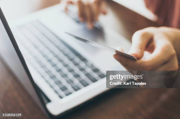 a young woman is using a laptop and credit card to buy online - daily life in philippines stock pictures, royalty-free photos & images