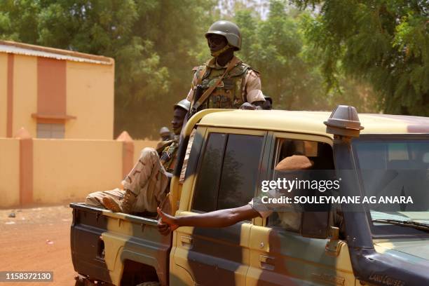 Members of the FAMA patrol in the streets of Gao, on July 24 a day after suicide bombers in a vehicle painted with UN markings injured one French,...