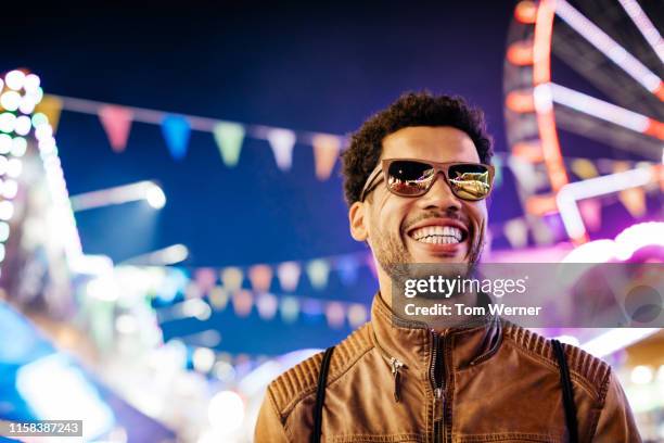 man enjoying evening at the fun fair - man sunglasses stock pictures, royalty-free photos & images