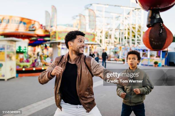 father about to hit punching bag at fun fair - festival day 11 fotografías e imágenes de stock