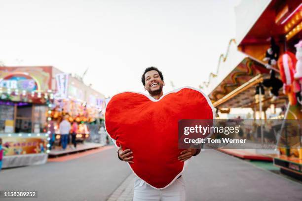 single dad holding large prize he won at fun fair - big tom stock-fotos und bilder