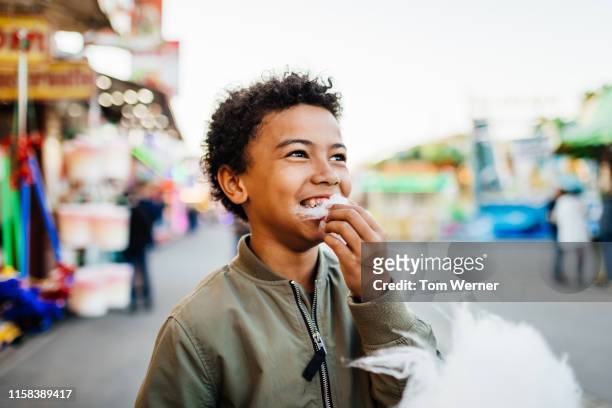 young boy enjoying some candy floss at fun fair - festival day 1 stock pictures, royalty-free photos & images