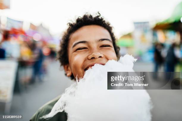 happy young boy eating candy floss - cotton candy stock pictures, royalty-free photos & images