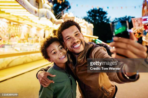 single dad taking selfie with son at the fun fair - festival of remembrance 2019 stock-fotos und bilder