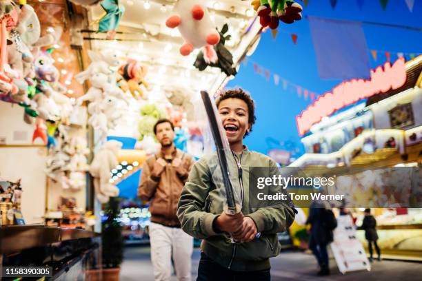 young boy showing off sword prize won at the fair - festival day 11 fotografías e imágenes de stock