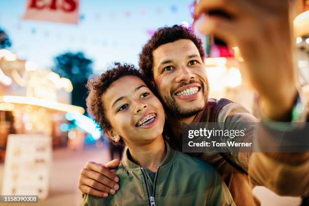 single father taking selfie with son - toothy smile family outdoors stock pictures, royalty-free photos & images