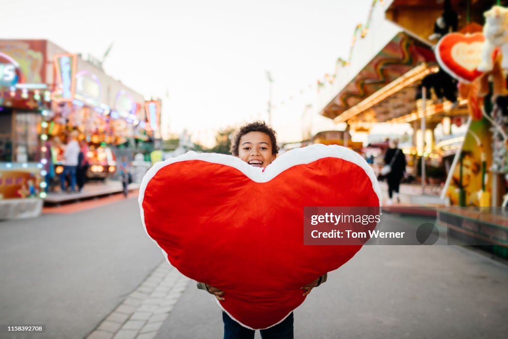 Young Boy Holding Large Prize He Won At Fun Fair