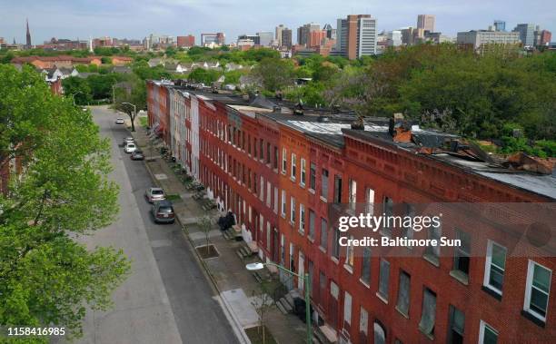 The Baltimore skyline is seen beyond the vacant row homes on the 800 block of Harlem Ave. The city has announced a $10 million redevelopment project...