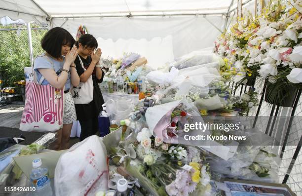 People pray in front of an altar set up near the three-story studio of Kyoto Animation Co. In Kyoto, western Japan, on July 29 11 days after an arson...