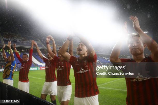 Urawa Red Diamonds players applaud away supporters after their 3-0 victory in the AFC Champions League round of 16 second leg match between Ulsan...