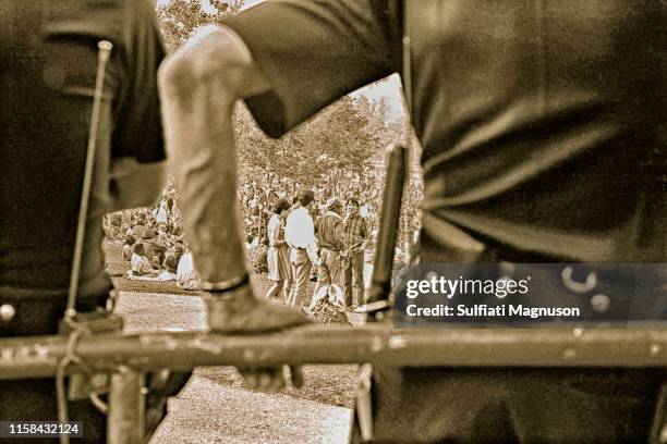 Three men and a woman seen standing through the portal of one of the many police who were assigned to "keep the peace" as the police academy was...