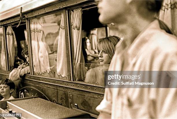 Musicians peering out of the old train car "dressing room": a blonde woman, two men; and a young boy looking at the camera at the 1st Elysian Park...