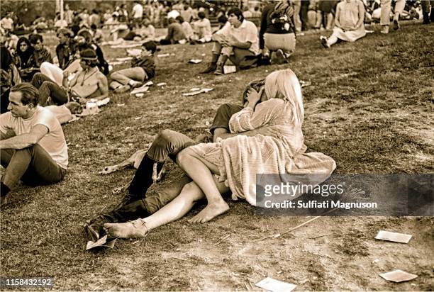 Kissing couple on bare grass who only have eyes for each other as surrounding crowd pays them no attention at the 1st Elysian Park Love-In on March...