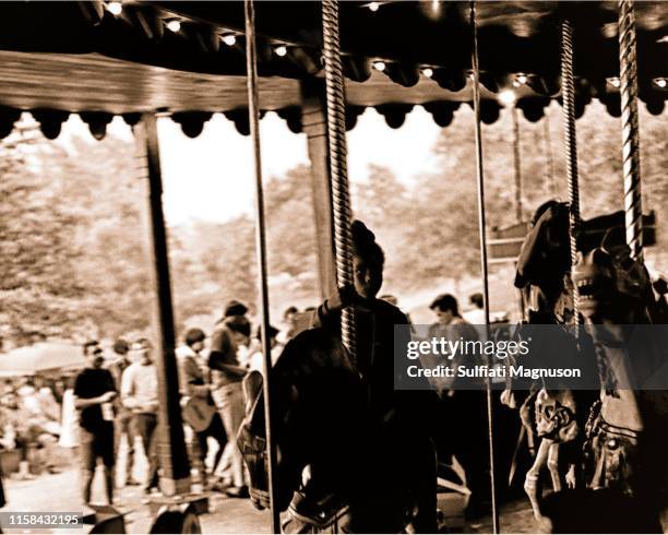 Young black girl riding the carousel at the 1st Elysian Park Love-In on March 26, 1967 in Los Angeles, California.