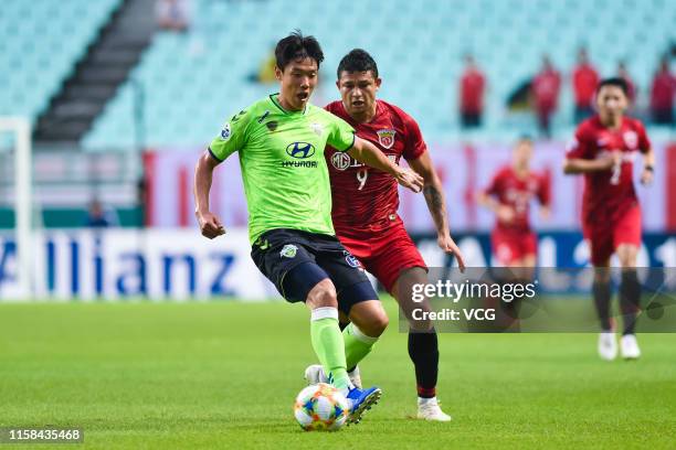 Hong Jeong-Ho of Jeonbuk Hyundai Motors and Elkeson of Shanghai SIPG compete for the ball during the AFC Champions League Round of 16 2nd Leg match...