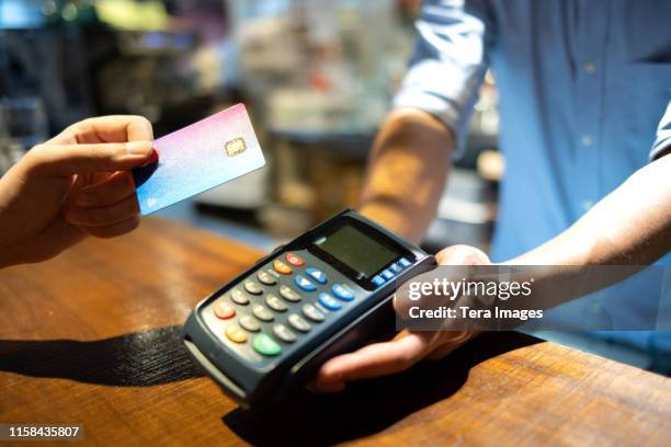 credit card payment machine - customers pay with contactless cards imagens e fotografias de stock