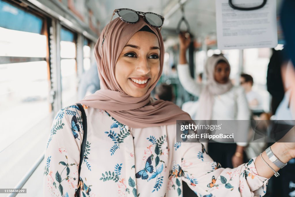 Friends talking together inside a bus in the city