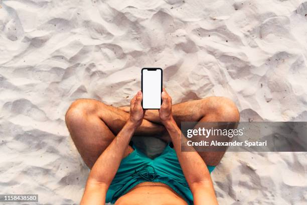 man using smartphone at the beach, personal perspective directly above view - sandy beach holiday stock pictures, royalty-free photos & images