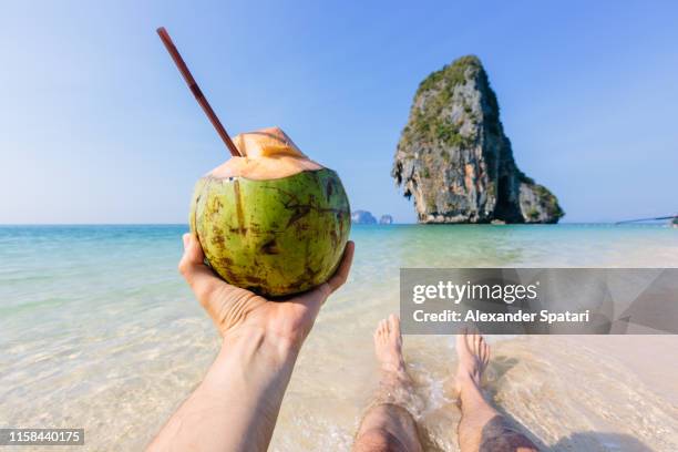 enjoying beach view and drinking coconut water, personal perspective view - coconut water stock pictures, royalty-free photos & images